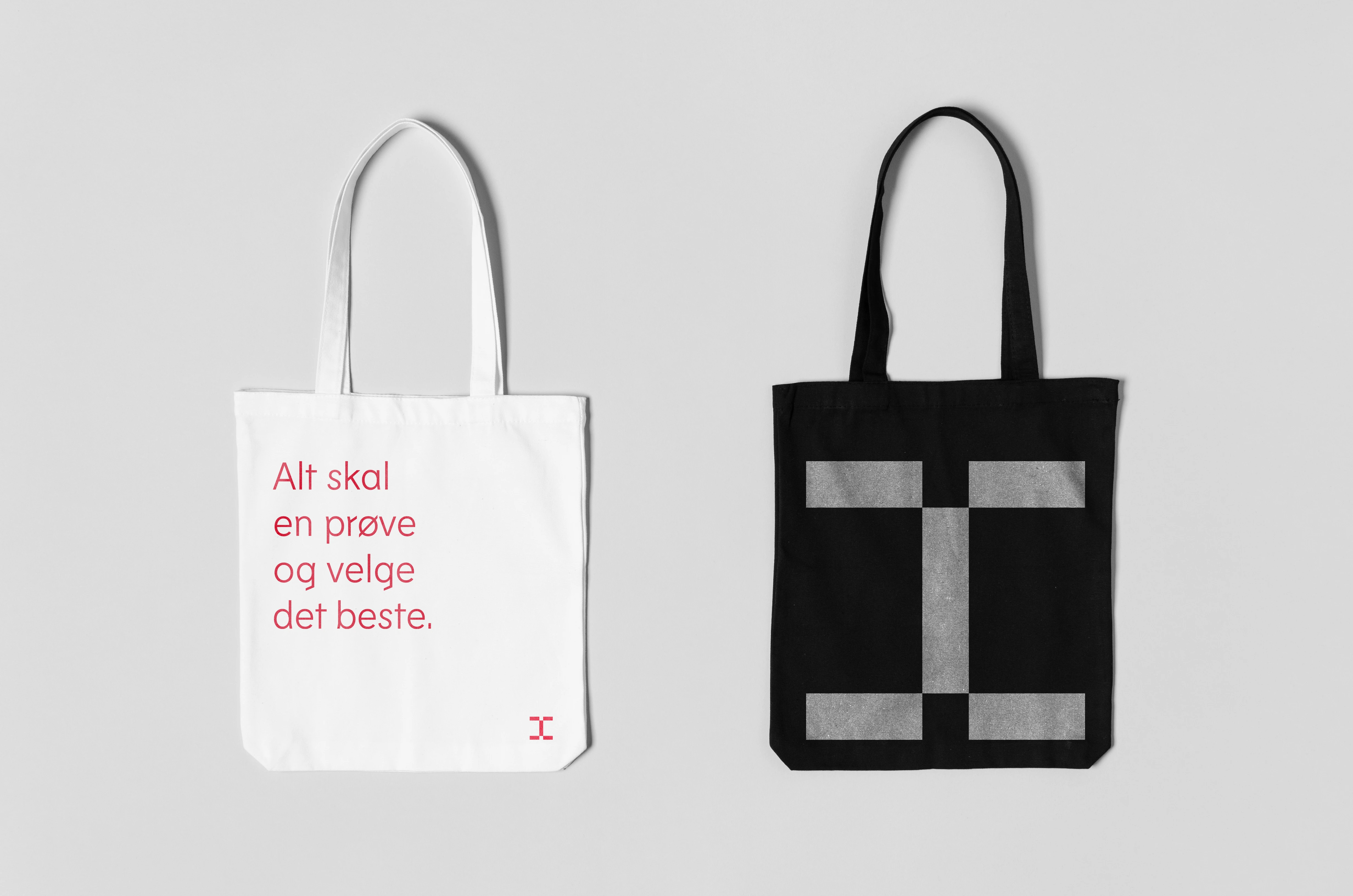 Handlenett i to varianter. En hvit med rødt tekst, "Alt skal en prøve og velge det beste". En sort med grått monogram